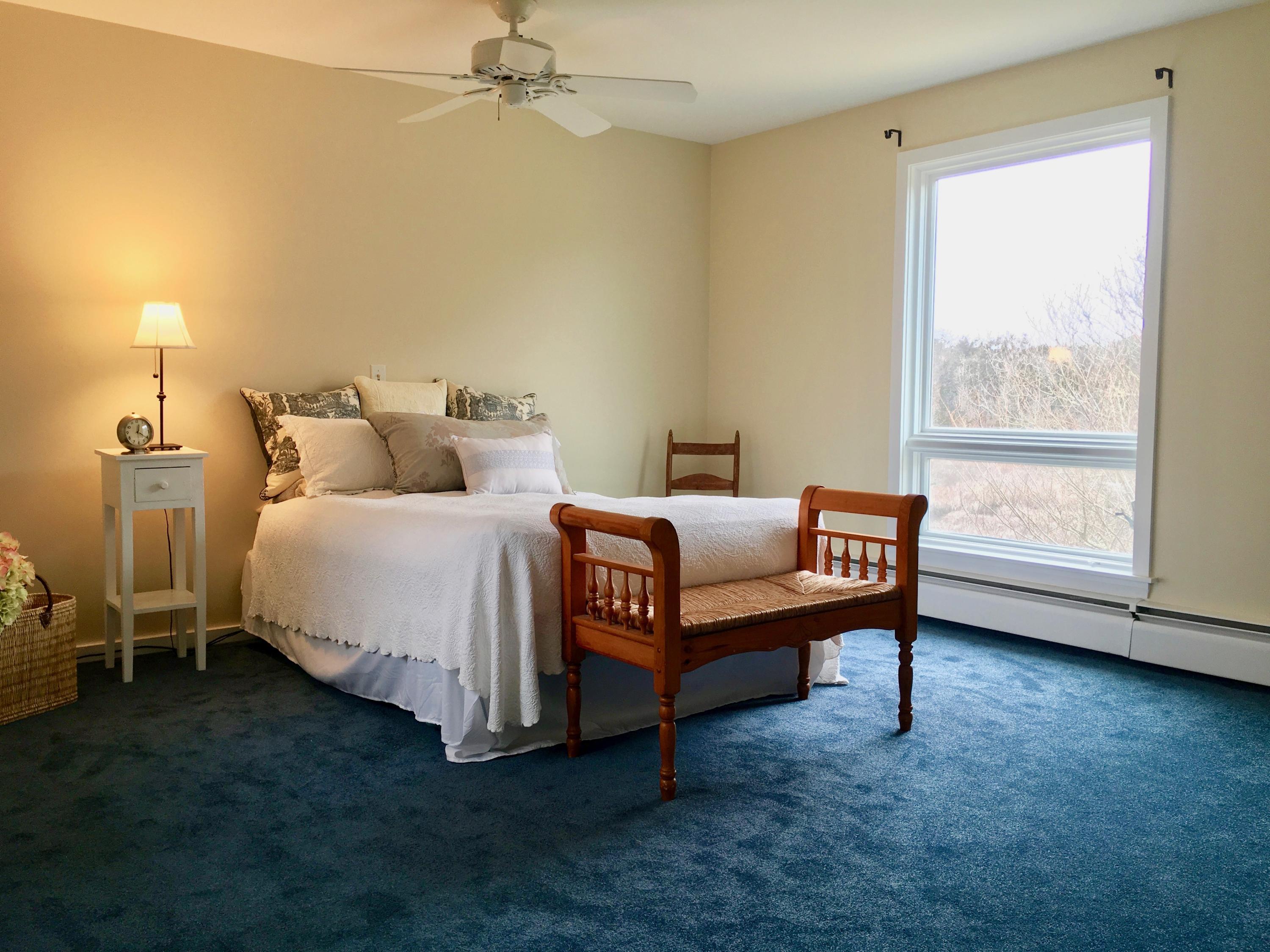 26 Champlain Road Orleans, MA 02653 - Photo 13 of 32 a spacious bedroom with a bed and a window