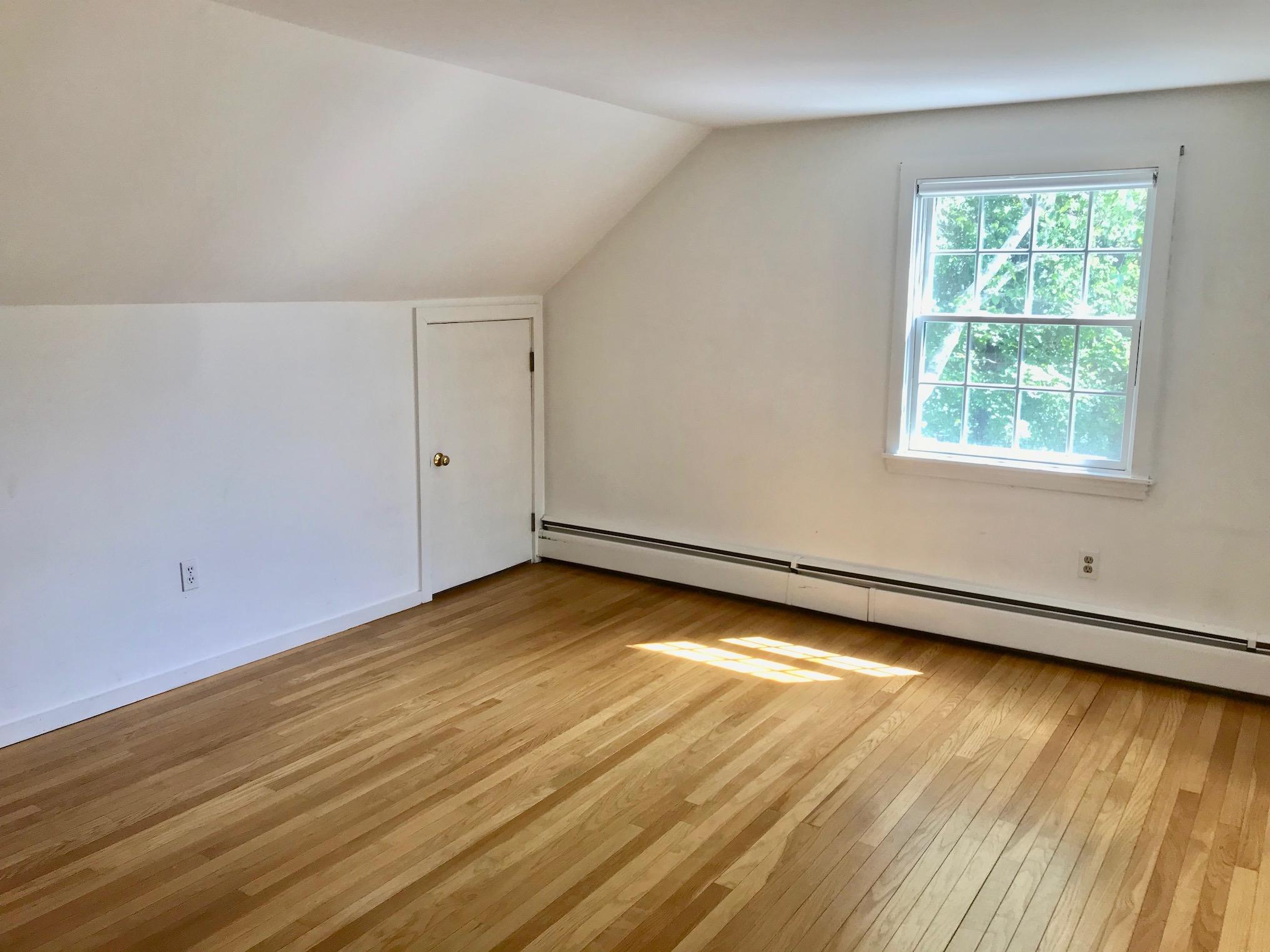 26 Champlain Road Orleans, MA 02653 - Photo 18 of 32 an empty room with wooden floor and windows