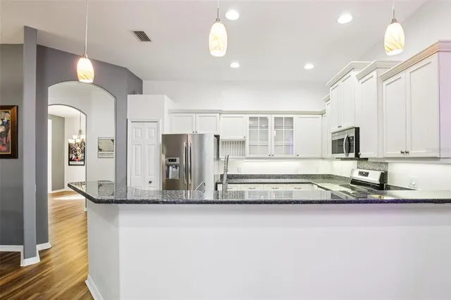 a kitchen with stainless steel appliances granite countertop a sink and cabinets