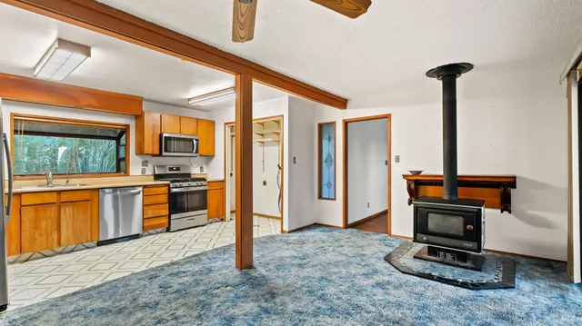 a kitchen with stainless steel appliances granite countertop a stove top oven a refrigerator and a sink