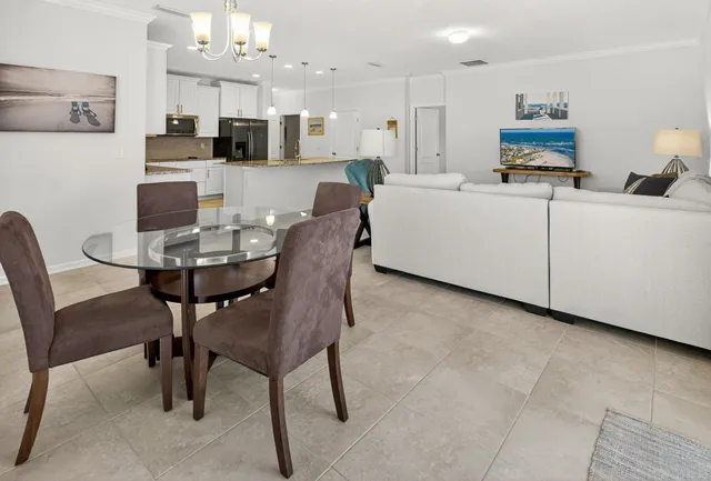 a view of a dining room with furniture a chandelier and a window