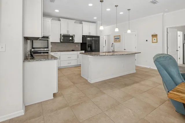 a living room with furniture a table and kitchen view