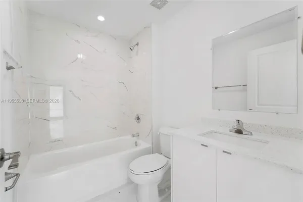 a bathroom with a sink toilet vanity and bathtub