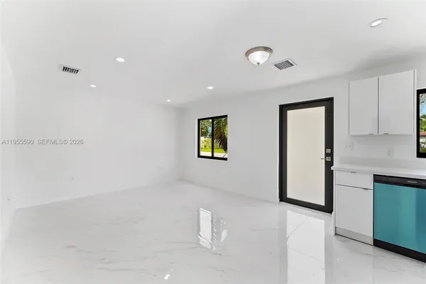 a view of an empty room with window and stairs