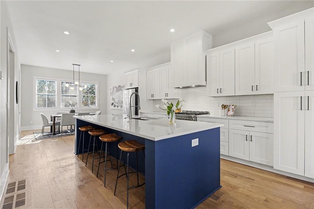 2149 Druid Flds Lane Decatur, GA 30033 - Photo 8 of 25 a kitchen with stainless steel appliances granite countertop a sink a stove a refrigerator and white cabinets with wooden floor