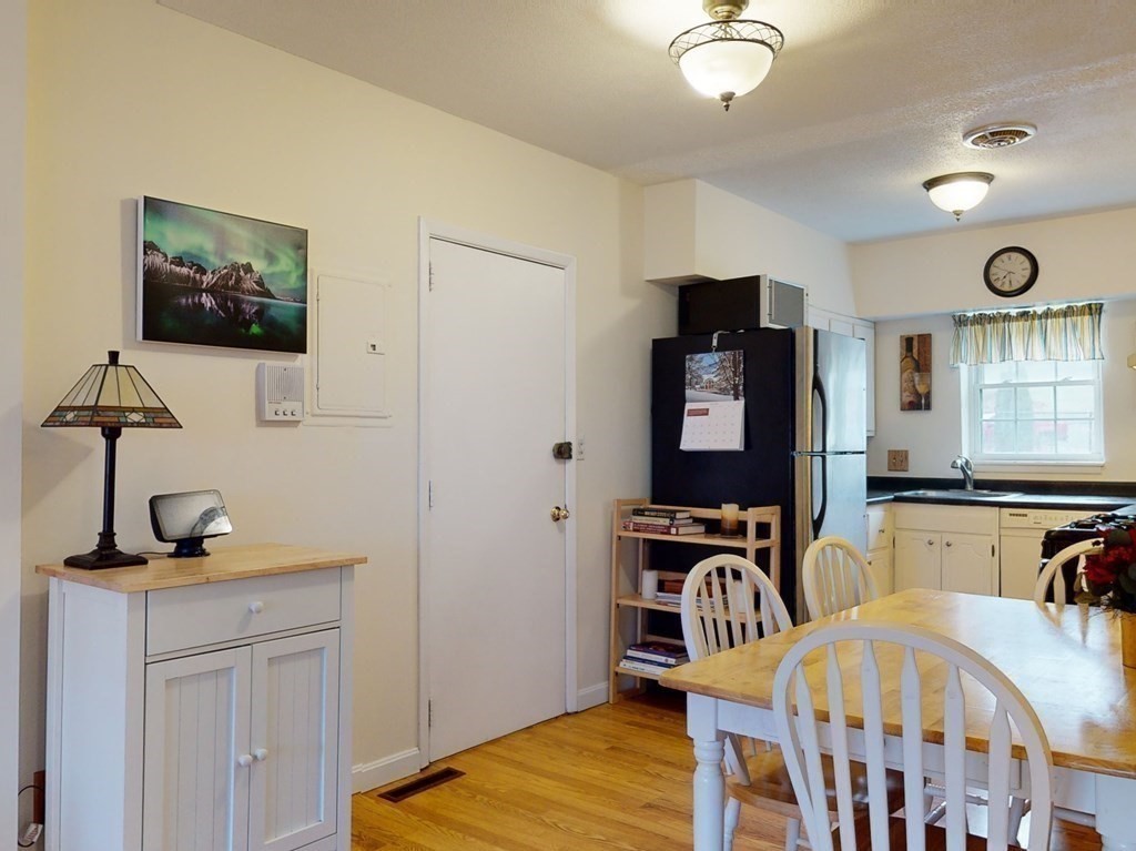 154 Lake Shore Road, Unit 2 Boston, MA 02135 - Photo 3 of 27 a bedroom with furniture and wooden floor
