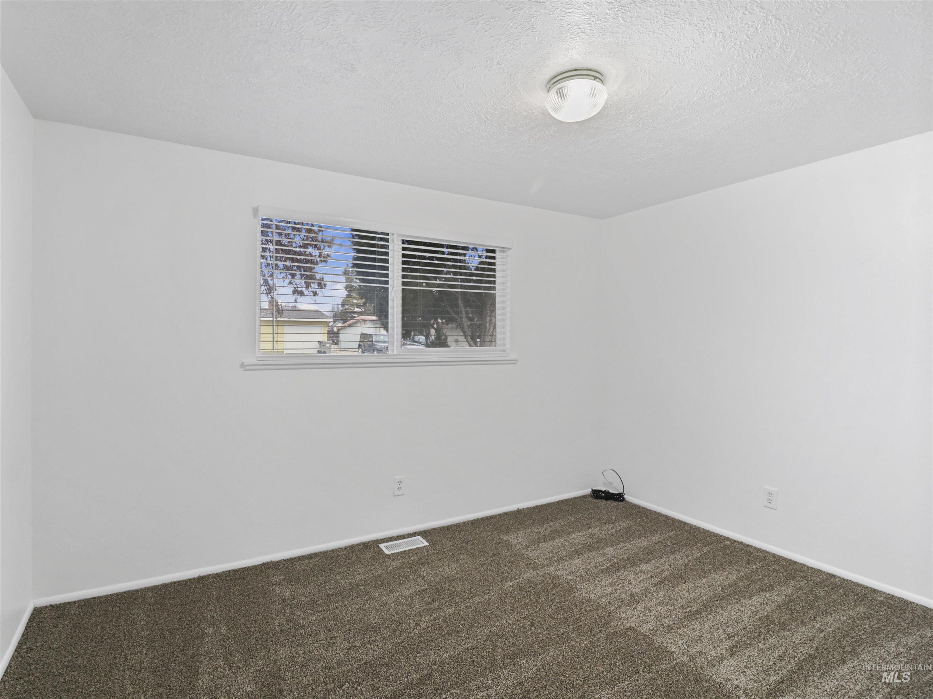 6739 West Grunder Street Boise, ID 83709 - Photo 15 of 24 Unfurnished room featuring a textured ceiling and dark colored carpet