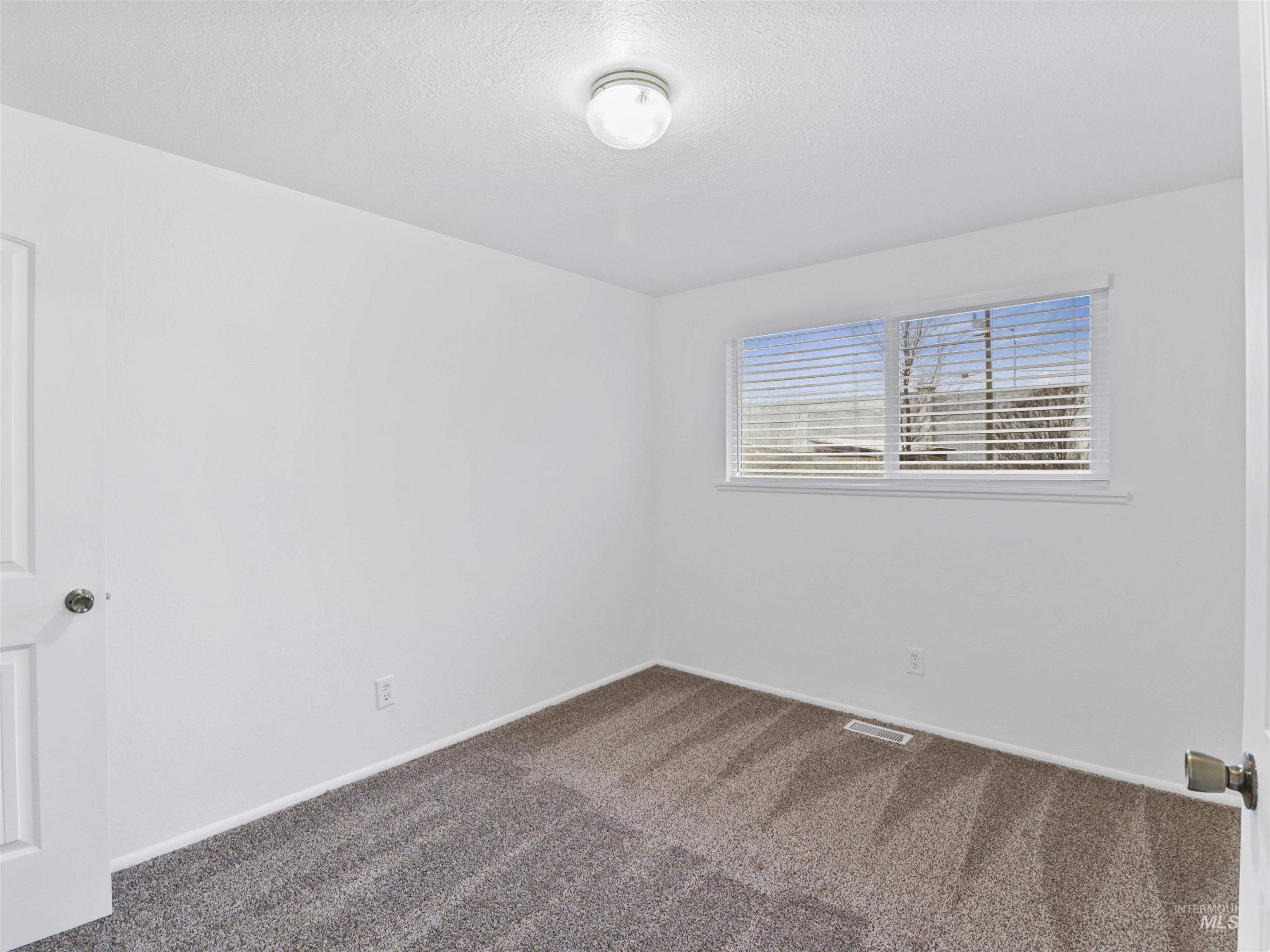 6739 West Grunder Street Boise, ID 83709 - Photo 17 of 24 Carpeted spare room featuring baseboards and a textured ceiling