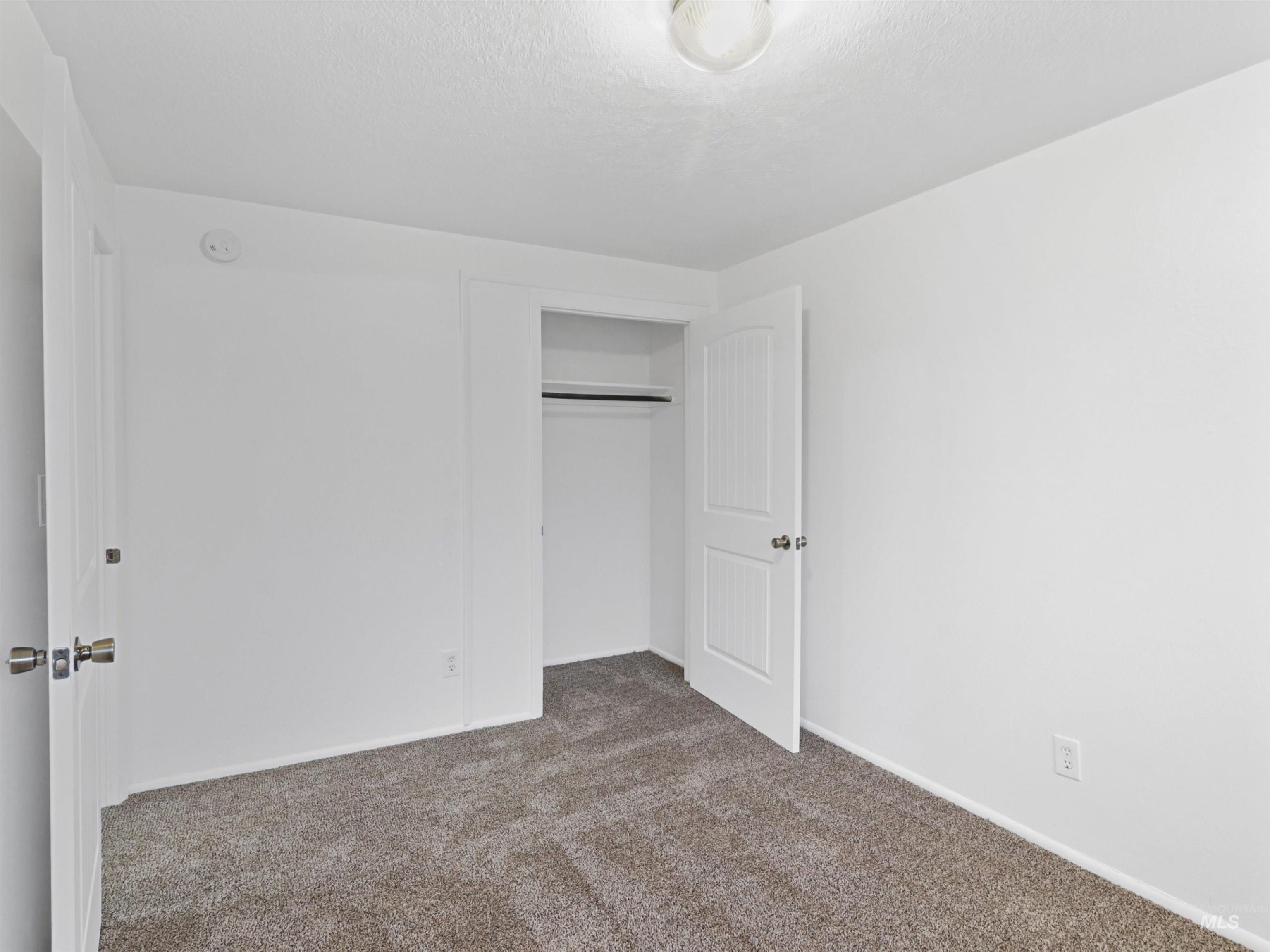 6739 West Grunder Street Boise, ID 83709 - Photo 18 of 24 Unfurnished bedroom with carpet flooring, a closet, and a textured ceiling