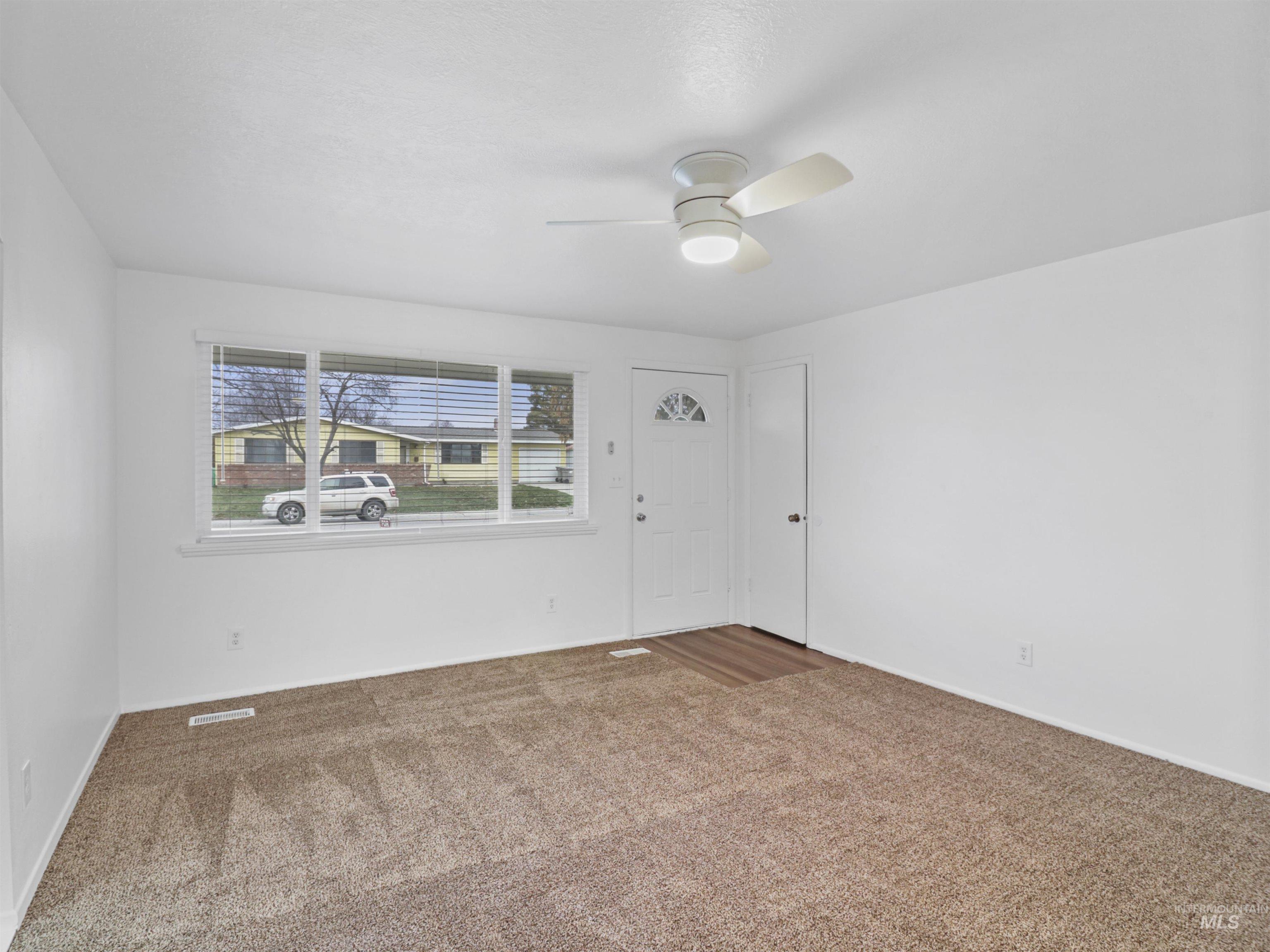 6739 West Grunder Street Boise, ID 83709 - Photo 2 of 24 Spare room featuring carpet flooring and a ceiling fan