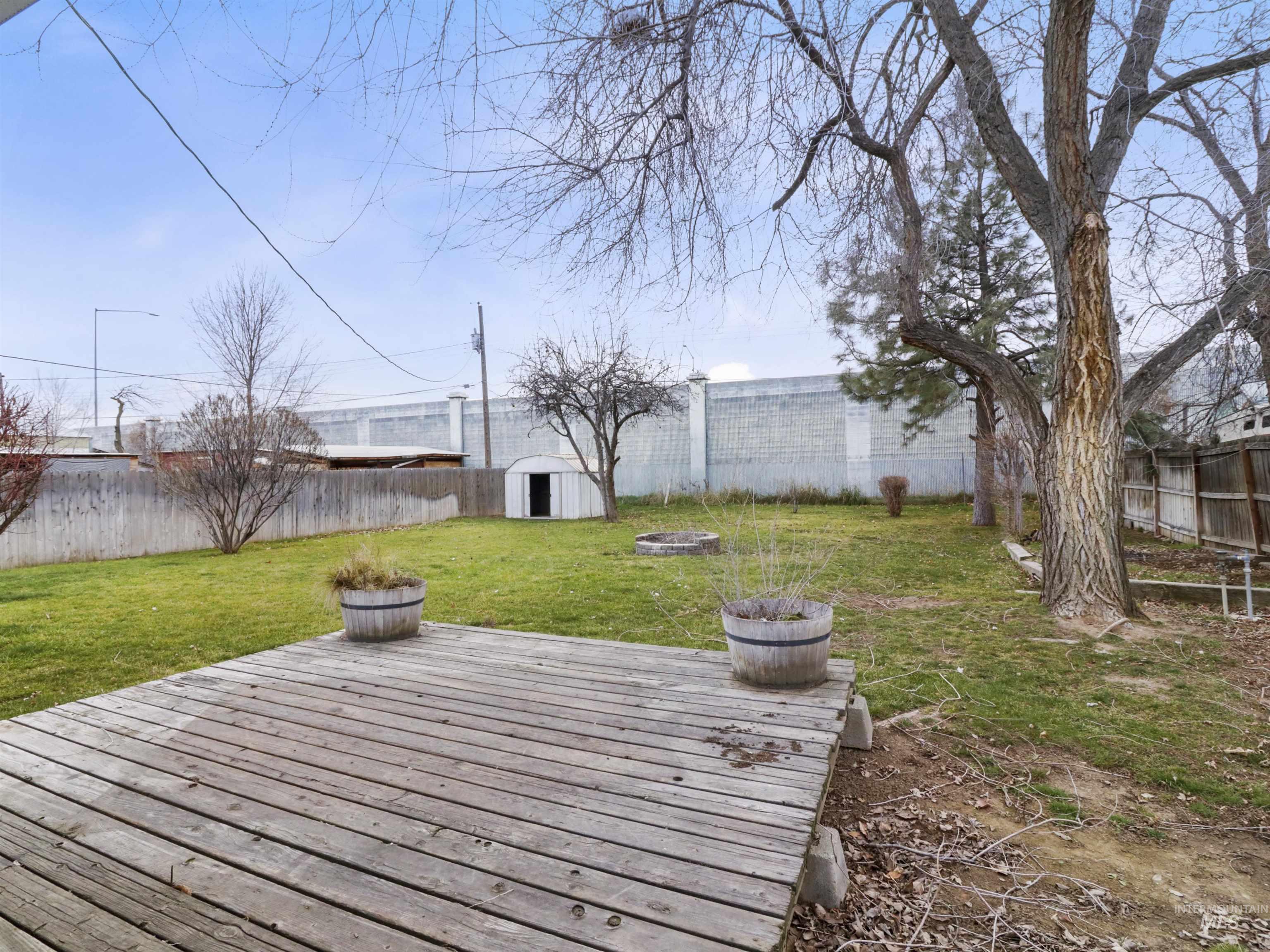6739 West Grunder Street Boise, ID 83709 - Photo 23 of 24 Wooden deck with a fenced backyard and a storage unit