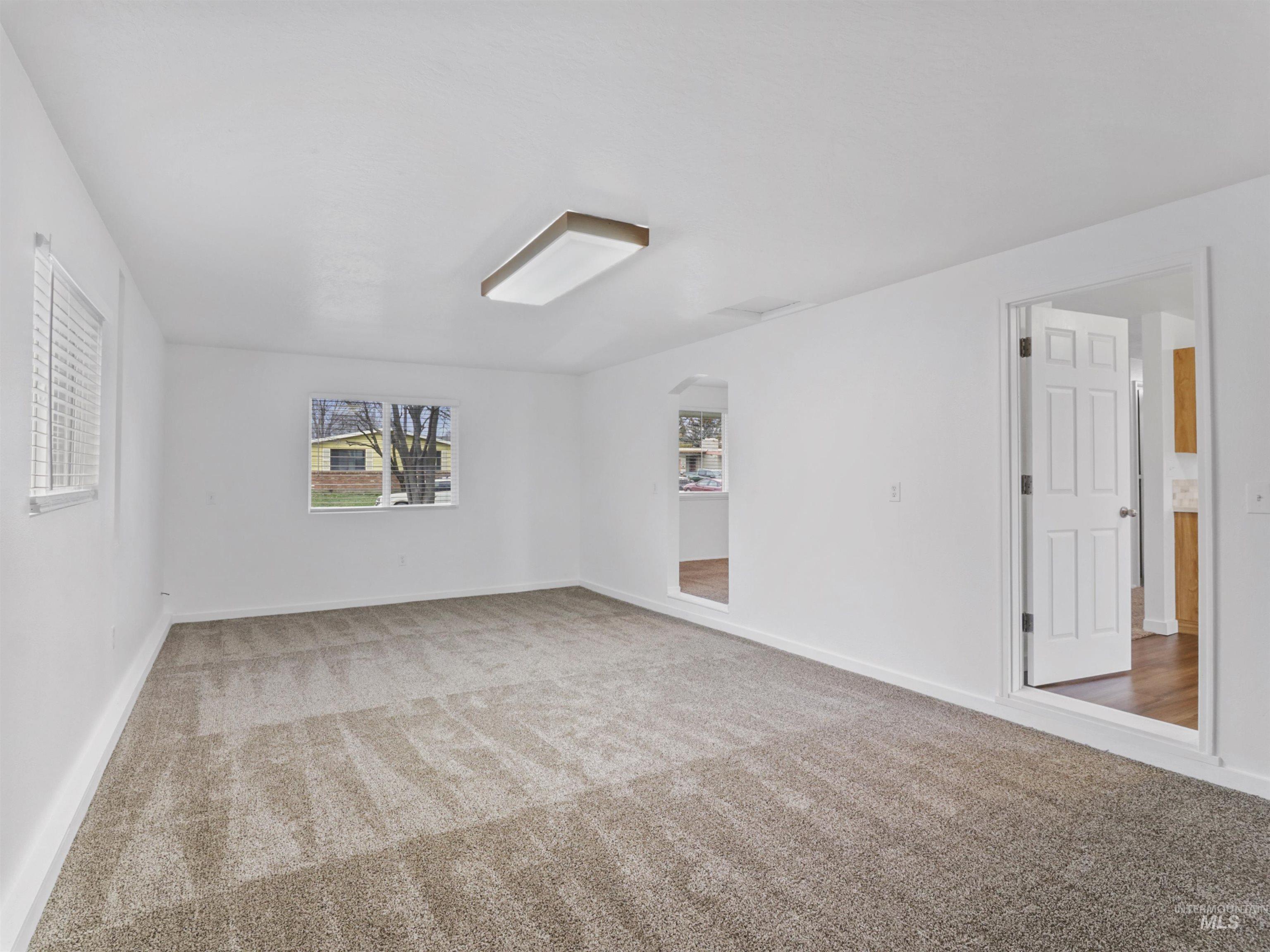6739 West Grunder Street Boise, ID 83709 - Photo 5 of 24 Carpeted empty room featuring baseboards and arched walkways