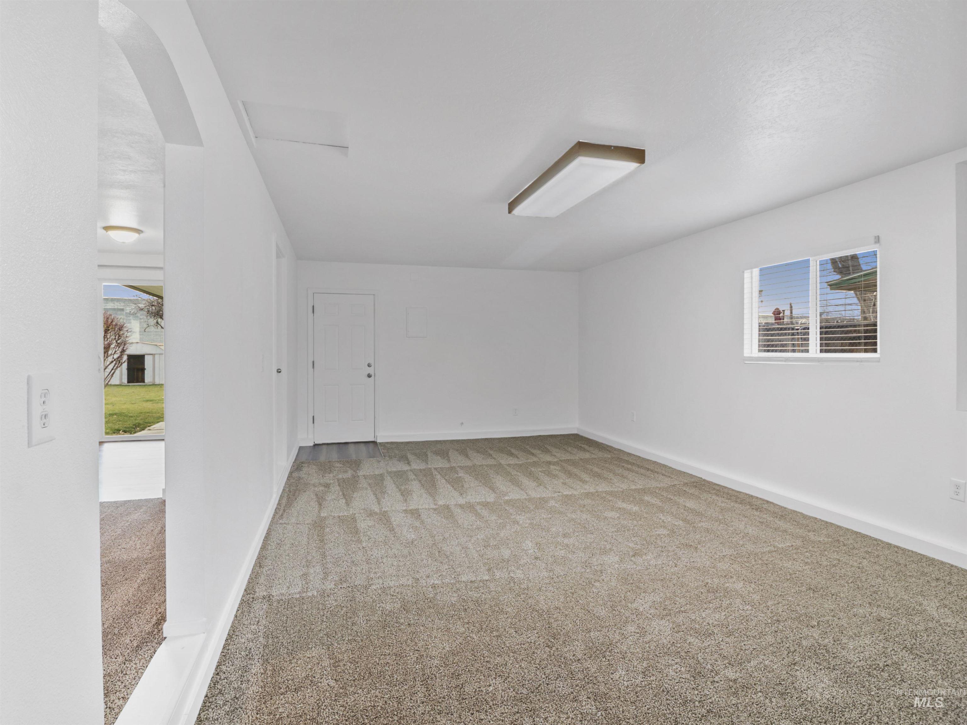 6739 West Grunder Street Boise, ID 83709 - Photo 6 of 24 Spare room featuring light carpet and arched walkways