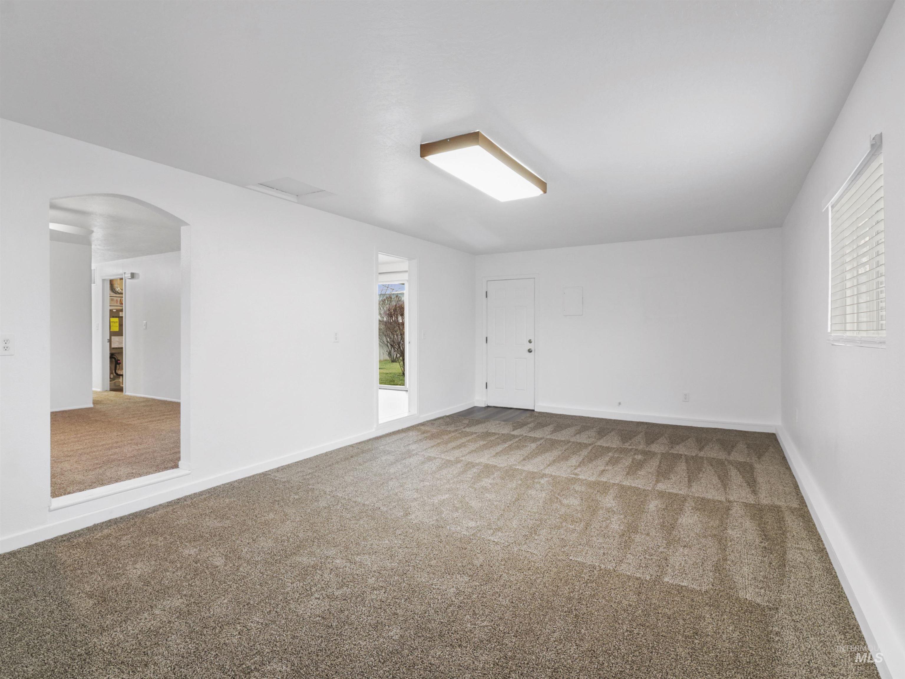 6739 West Grunder Street Boise, ID 83709 - Photo 7 of 24 Carpeted empty room featuring arched walkways and baseboards