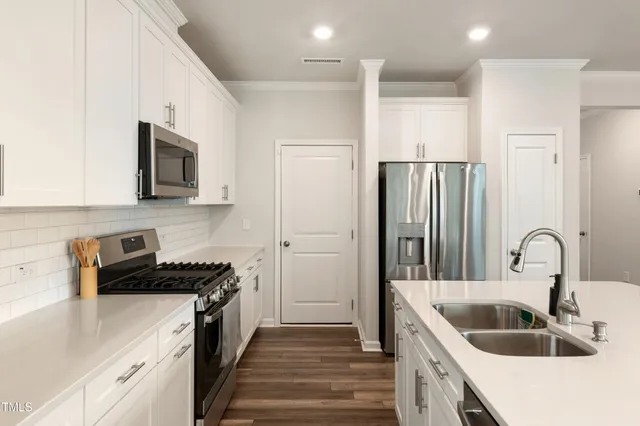 a kitchen with sink a refrigerator and cabinets