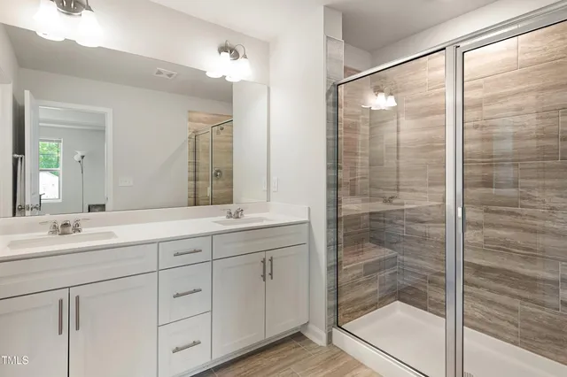 a bathroom with a double vanity sink and mirror