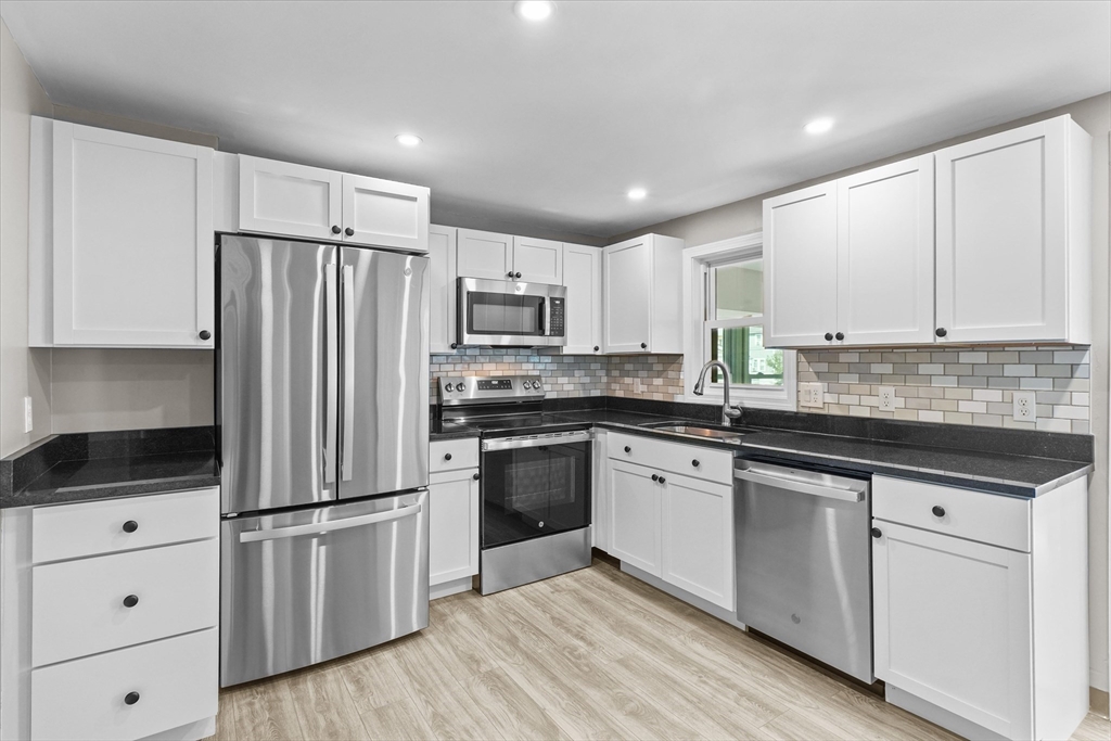 25 Purchase Street Danvers, MA 01923 - Photo 12 of 42 a kitchen with granite countertop white cabinets and stainless steel appliances