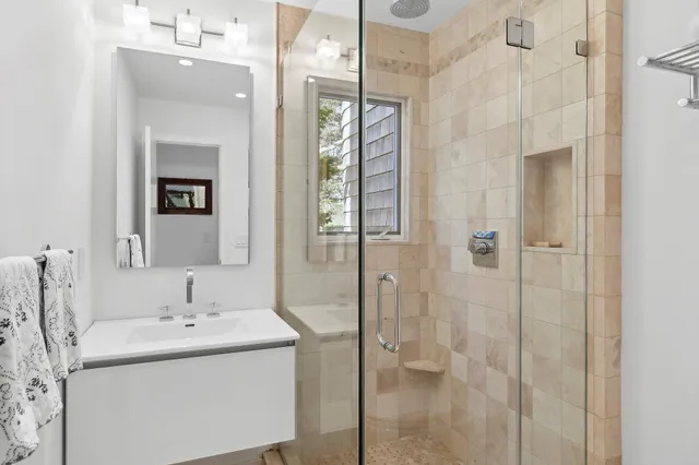 a bathroom with a sink vanity and shower