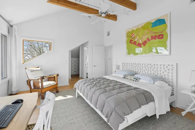 a bedroom with a bed and painting on the wall