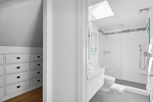 a bathroom with a granite countertop shower a toilet and a shower