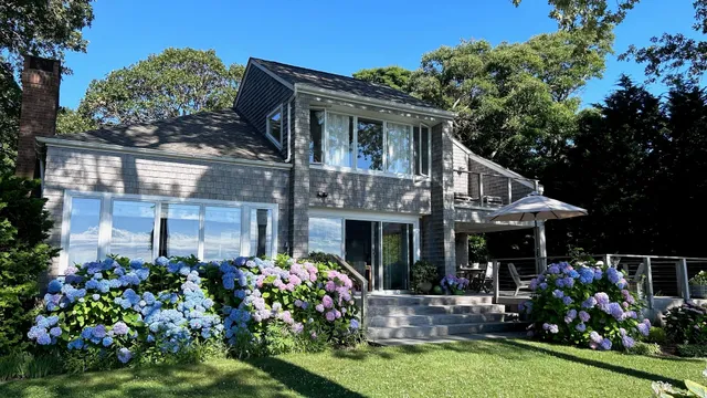 a view of house with a yard and potted plants
