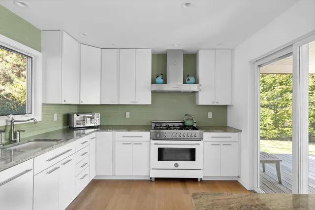 a kitchen with stainless steel appliances white cabinets and a wooden floor