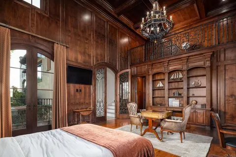 a bedroom with a large bed and a chandelier