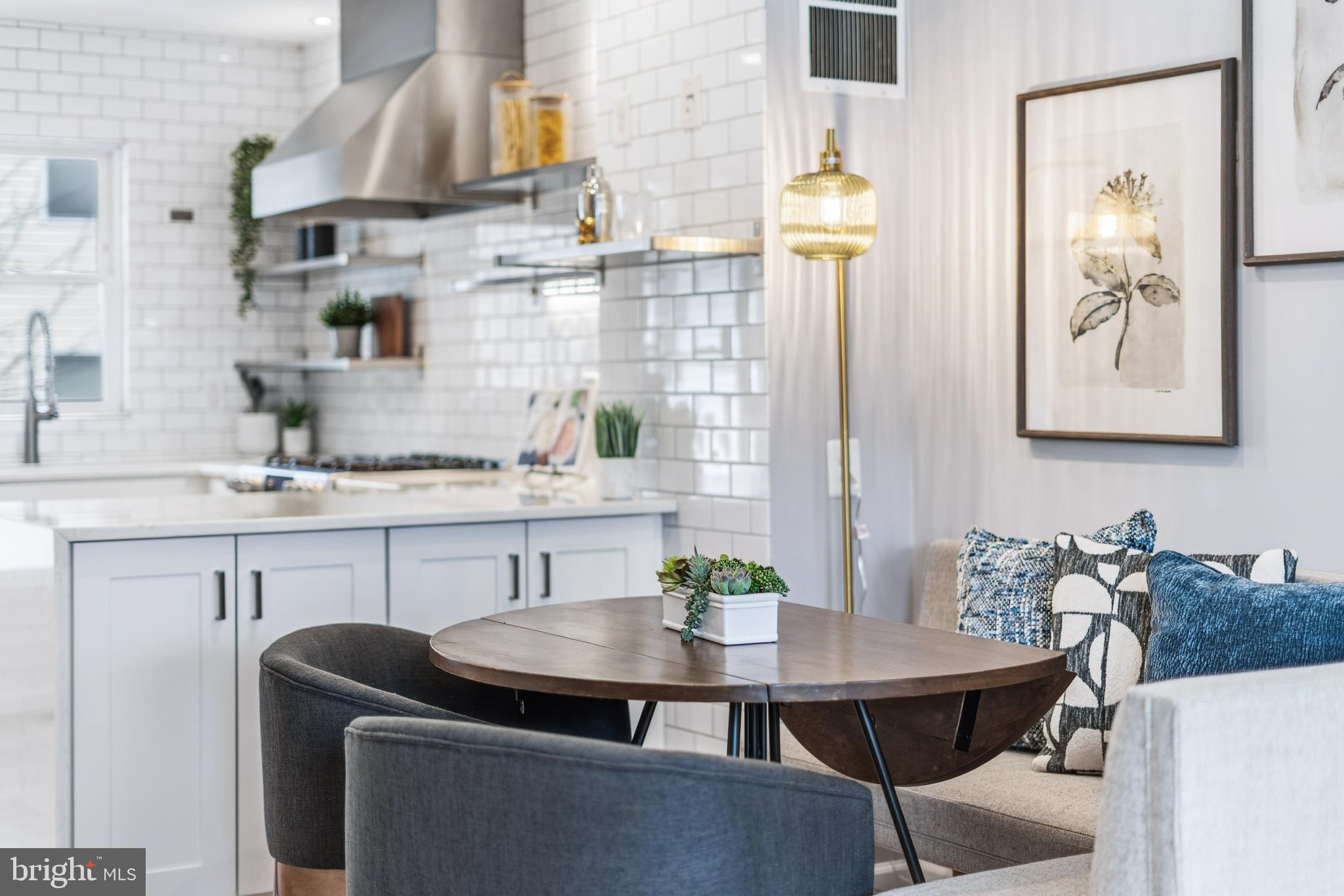 353 L Street Southeast Washington, DC 20003 - Photo 8 of 36 a kitchen with stainless steel appliances kitchen island granite countertop a table chairs in it and wooden floor