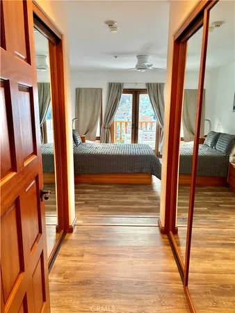 a spacious bedroom with a bed and a flat tv screen on dresser