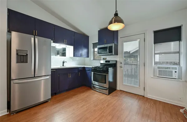 a kitchen with stainless steel appliances a refrigerator and a stove top oven