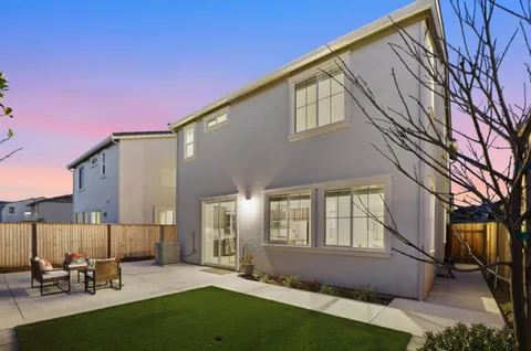 a backyard of a house with table and chairs