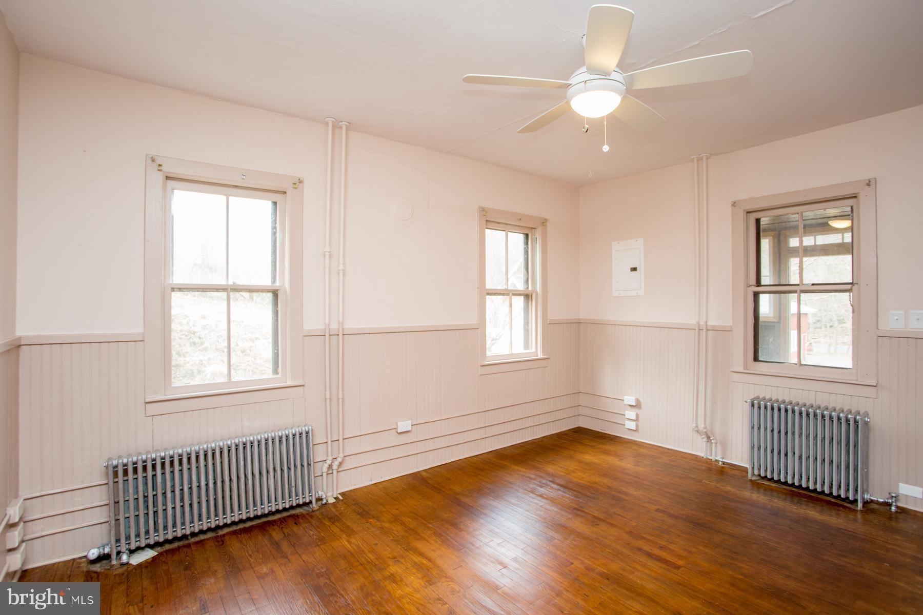120 Tabor Road Ottsville, PA 18942 - Photo 27 of 60 an empty room with wooden floor chandelier fan and windows