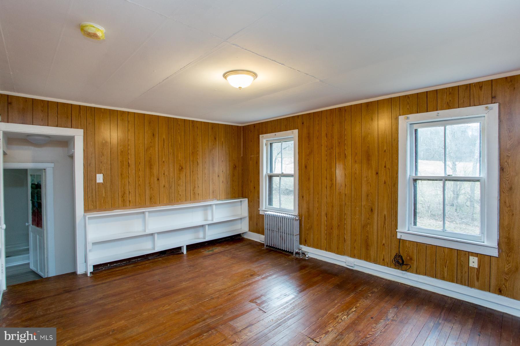 120 Tabor Road Ottsville, PA 18942 - Photo 38 of 60 an empty room with wooden floor and windows with curtains