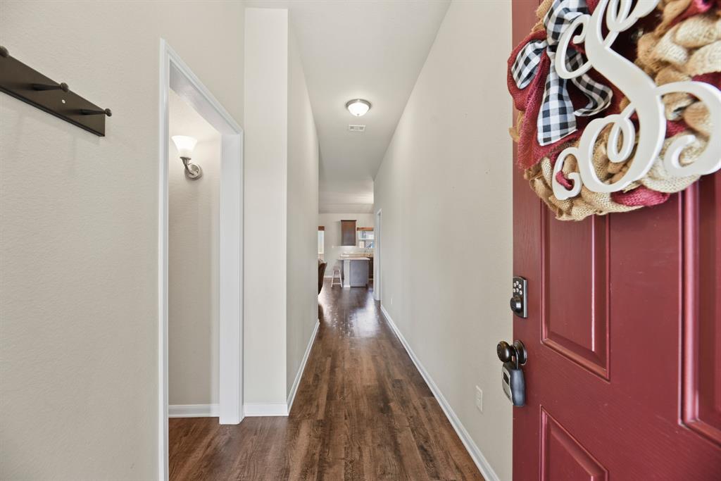 a view of a hallway with wooden floor and a white door