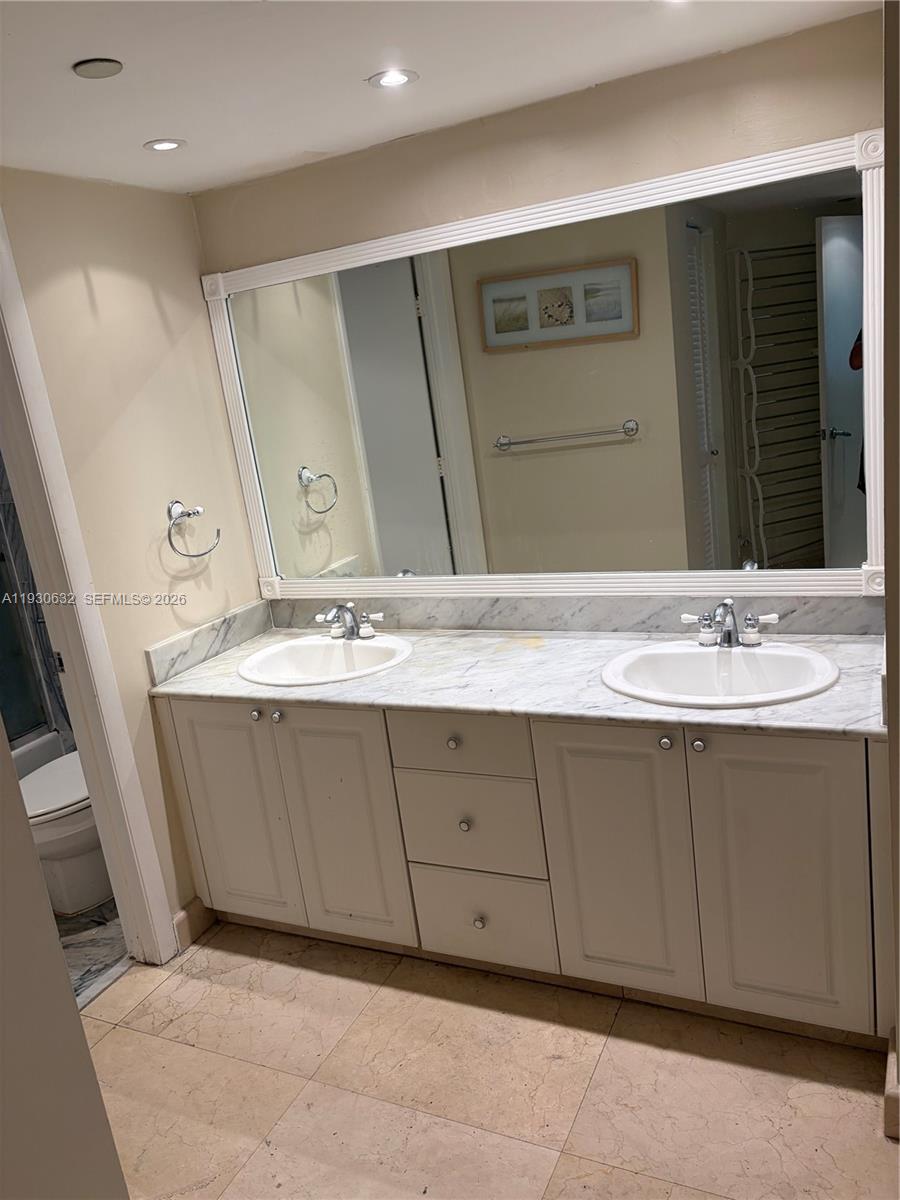 8911 Collins Avenue, Unit 303 Surfside, FL 33154 - Photo 14 of 16 a bathroom with a sink and a mirror