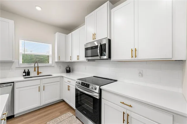 a kitchen with stainless steel appliances white cabinets and a sink