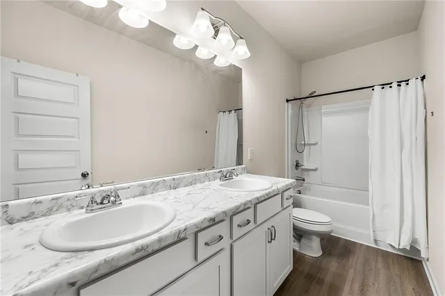 a bathroom with a granite countertop sink a toilet and bathtub