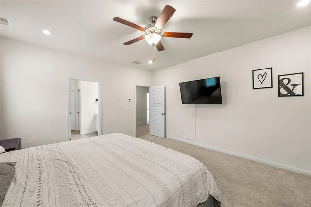 a bedroom with a bed tv and a wall painting