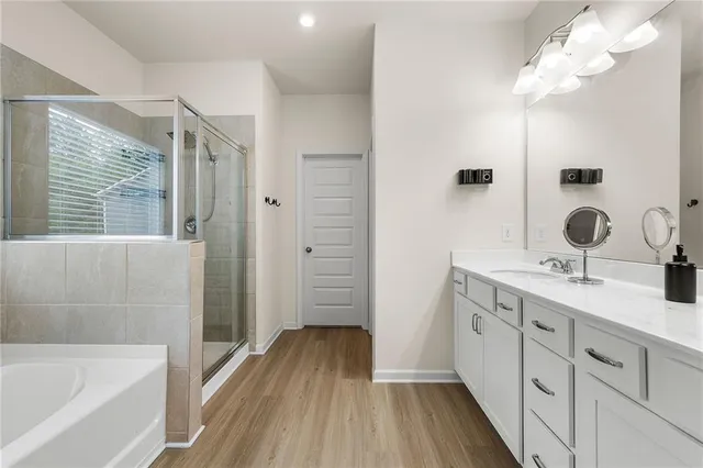 a bathroom with a double vanity sink a mirror and a bathtub
