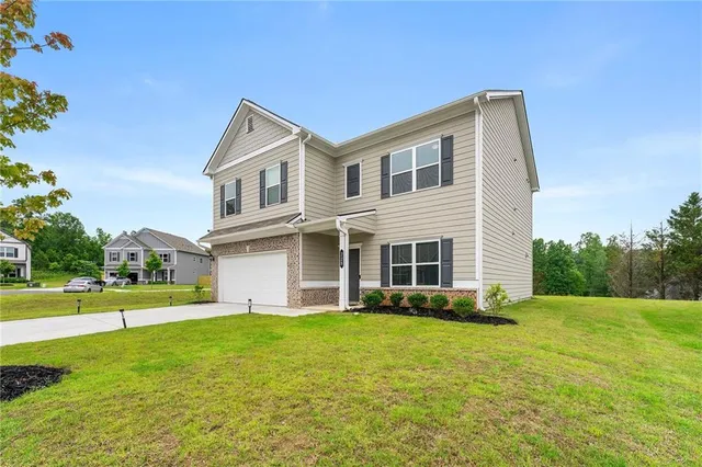 a view of a house with a yard and sitting area