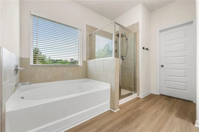 a white bath tub sitting in a bathroom near shower