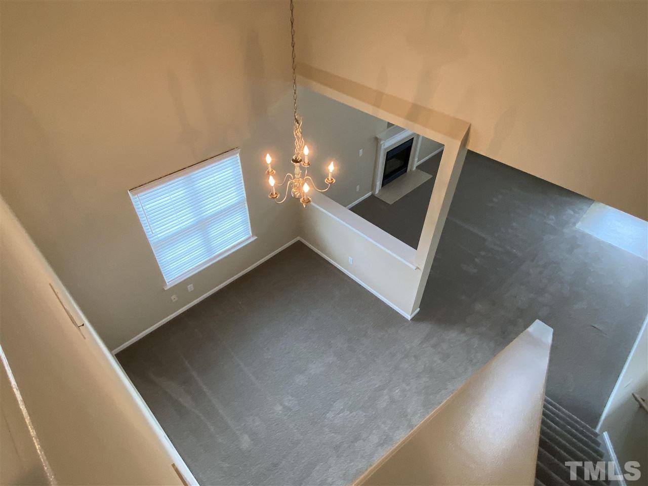 4802 Cutstone Court Raleigh, NC 27610 - Photo 8 of 13 a view of an empty room with wooden floor and stairs