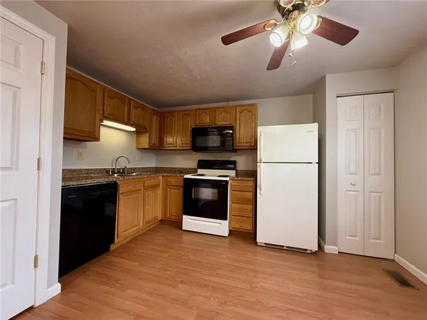 a kitchen with a refrigerator and a stove top oven