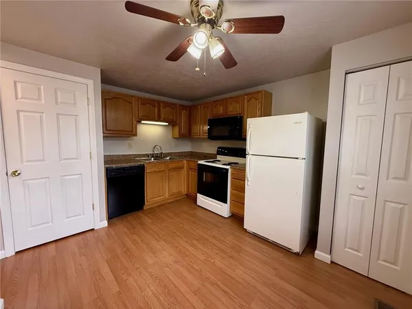 a kitchen with stainless steel appliances granite countertop a refrigerator a sink dishwasher a stove and a refrigerator