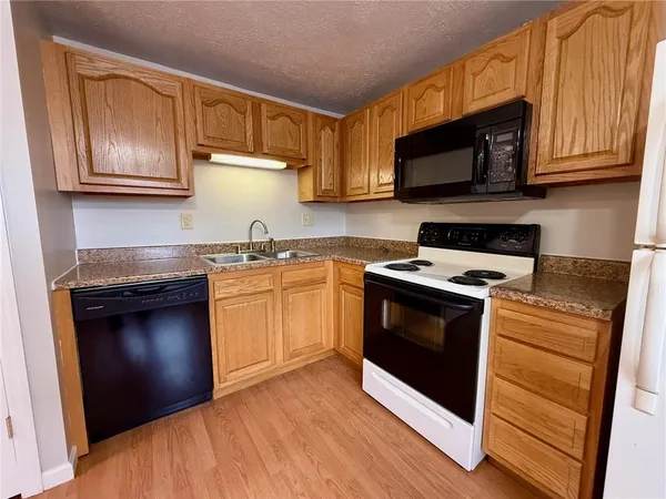a kitchen with stainless steel appliances granite countertop a stove a microwave and a sink