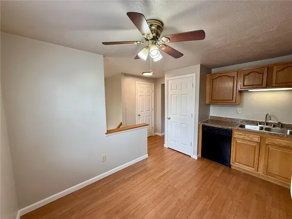 a kitchen with granite countertop a stove cabinets and wooden floor