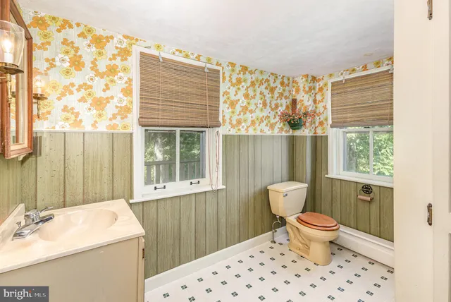 a bathroom with a sink toilet and a window