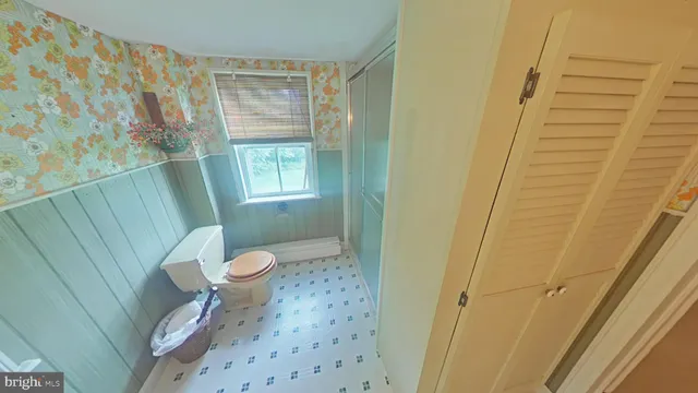 a white toilet sitting next to a shower curtain