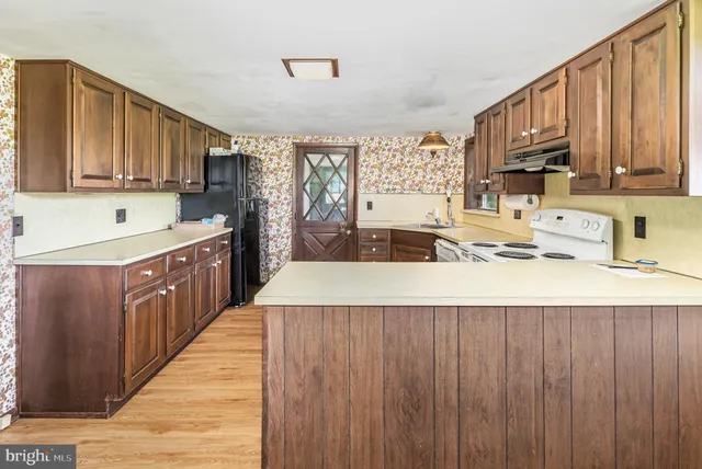 a kitchen with stainless steel appliances granite countertop wooden cabinets a sink and dishwasher a oven with wooden cabinets