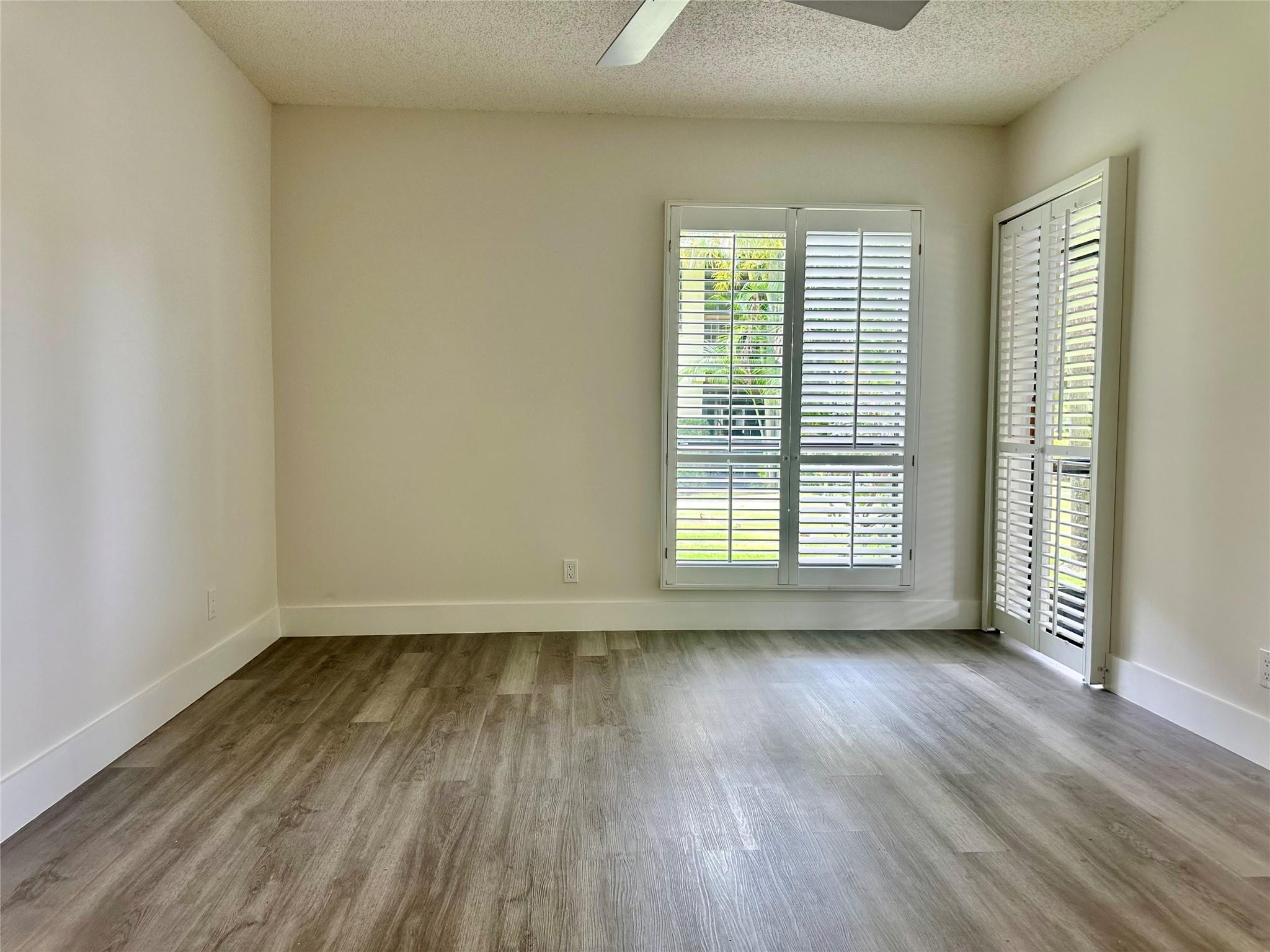 159 Northwest 70th Street, Unit 517 Boca Raton, FL 33487 - Photo 17 of 30 a view of an empty room with wooden floor and a window